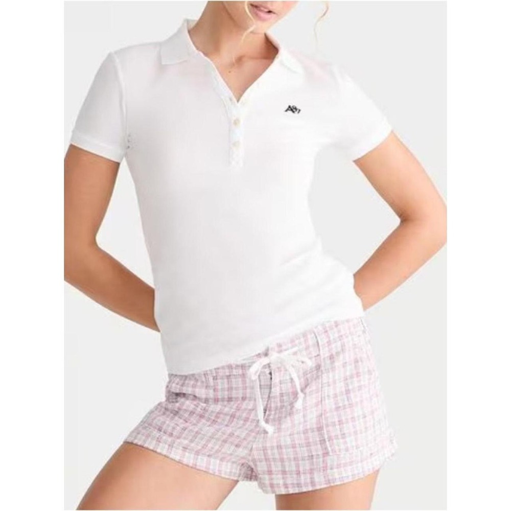 Simple knit polo with short sleeves. Subtle stitched brand label at collar. C...